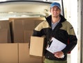 We do same-day delivery for your convenience. Portrait of a delivery man unloading boxes from his van. Royalty Free Stock Photo