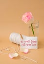 DO SMALL THINGS WITH GREAT LOVE quote Tender pink roses with spool of white cotton rope in heart shape on beige