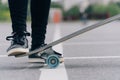 Do stunts on the longgord while riding on a board on the asphalt. Closeup of your skateboard leg