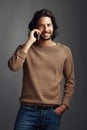 Do you have my number in your contact list. Studio shot of a handsome young man using a mobile phone against a gray