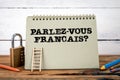 Do you speak French. Written in French. Green notepad on wooden texture table and white background Royalty Free Stock Photo