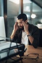 Do you really want to be defeated by the deadline. a young businessman feeling stressed while working late at night in a Royalty Free Stock Photo