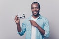 Do you want to try on? Portrait of confident happy smiling joyous cheerful excited afro man wearing casual clothing pointing on g