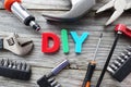 Do it yourself concept with DIY acronym from plastic letters in the middle of tools prepared for work