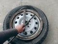 Do-it-yourself emergency tire fitting of a tubeless tire on the road. Driver uninstalling broken tire on car at the road