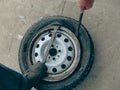 Do-it-yourself emergency tire fitting of a tubeless tire on the road. Driver uninstalling broken tire on car at the road