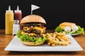 Doble burger with doble cheddar cheese, lettuce, bacon, mushrooms and french fries Royalty Free Stock Photo