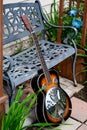 Dobro Style Guitar Leaning against Metal Bench