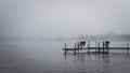 Dock with benches on foggy lake in Bemidji Minnesota Royalty Free Stock Photo