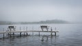 Dock with benches on foggy lake in Bemidji Minnesota