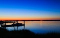 Dock, boat and marshes at sunset and blue hour off New Jersey inlet.