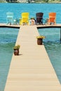 Dock with colorful adirondack chairs Royalty Free Stock Photo