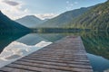 Dock leading into a beautiful mountain lake in the Austrian alps Royalty Free Stock Photo