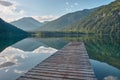 Dock leading into a beautiful mountain lake in the Austrian alps Royalty Free Stock Photo