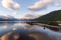 Dock over of lake Mcdonald surrounded by mountains during sunset Royalty Free Stock Photo