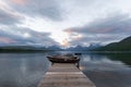 Dock over of lake Mcdonald surrounded by mountains during sunset Royalty Free Stock Photo