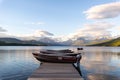 Dock over of lake Mcdonald surrounded by mountains during sunset Royalty Free Stock Photo