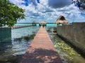 Dock with palm roof above a multicolor lake in Bacalar, Mexico.