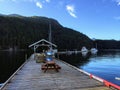 A dock with sailboats tied to it during dusk on a beautiful evening in remote bay with still, calm water.