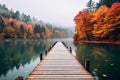 A dock with wooden path on a lake with autumn forest landscape. Beautiful fall nature background, calm blue water in the river Royalty Free Stock Photo