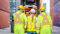 Dock workers in safety gear stand in front of cargo containers Royalty Free Stock Photo