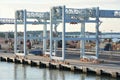 Dock workers walk approach high profile container crane at shift change