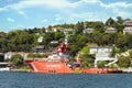 Docked orange coastal safety ship, at the Asian side of Bosphorus, with green mountains, Istanbul, Turkey