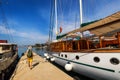 Docked ship in port. Docking on the pier in the Mediterranean. Yacht parked at dock. Tourist with backpack walking on the pier