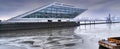The Dockland, a futuristic office building in the port of Hamburg, in gloomy weather and draining water on the river Elbe