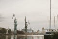 Docks on the Martwa Wisla in Poland city of GdaÃâsk with docked cargo ship under repair and port cranes in background during