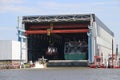 Docks with ships and cranes along the riverside of the river Lek or Noord in the Netherlands.