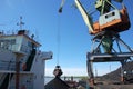 Dockside cargo crane loads coal at river port Kolyma Royalty Free Stock Photo