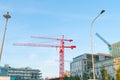 Dockside construction with two red cranes against blue morning sky