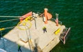 Dockworkers attaching moored ship`s hawser to shoreside bitt in seaport`s dock