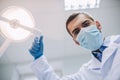 Doctor adjusting lamp in modern dental clinic