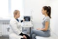Doctor advises the patient`s girl after an ultrasound diagnosis. indicates with a pen on the monitor of the ultrasound machine th