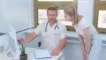 the doctor advises the young patient at the reception, explains, shows the results of the medical examination on the