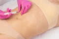 A doctor of aesthetic cosmetology makes lipolytic injections to burn body fat on a womanÃ¢â¬â¢s stomach and body. Female aesthetic