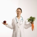 Doctor, apple and carrots. Royalty Free Stock Photo