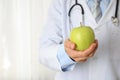 Doctor with apple and stethoscope, close up Royalty Free Stock Photo