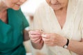 Doctor applying hearing aid to senior woman`s ear