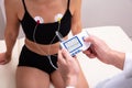 Doctor Applying Holter Heart Monitor On Woman`s Body In Clinic