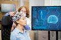 Doctor arranging scanning device on head of a female patient