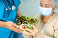 Doctor and Asian senior or elderly old lady woman patient holding breakfast vegetable healthy food with hope and happy while
