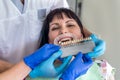 Doctor and assistant comparing patient`s teeth with sampler Royalty Free Stock Photo