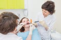 Doctor and assistant making Caries treatment to Patient at a dentist office