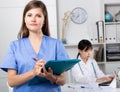 Doctor assistant standing in medical office noting prescriptions