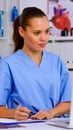 Doctor assistant in uniform working on laptop in modern hospital