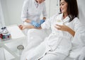 Doctor attaching intravenous drip on lady hand while she drinking water Royalty Free Stock Photo