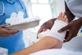 Doctor bandaging patients leg